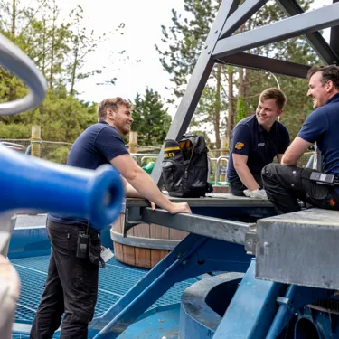 Three Chessington World of Adventures maintenance staff members smiling