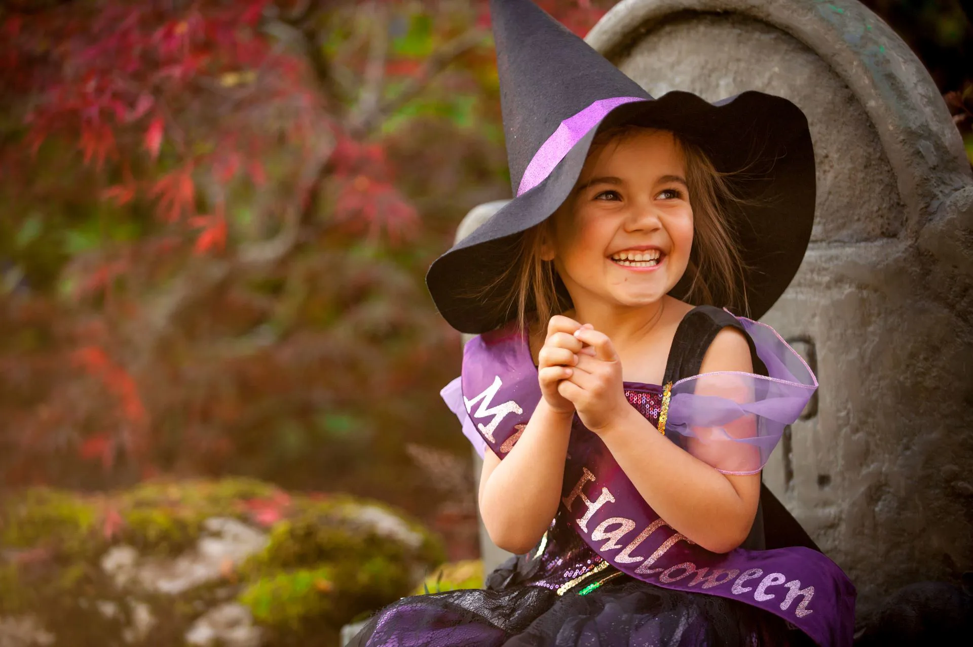 Little Girl dressed in a purple and black witch outfit 